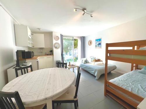 Cette chambre comprend une cuisine, une table et un lit. dans l'établissement Entre Étang et Mer - Parking - Cadre Verdoyant, à La Grande Motte