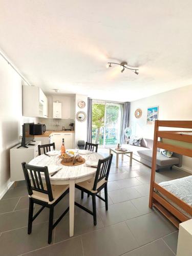 une cuisine et une salle à manger avec une table et des chaises dans l'établissement Entre Étang et Mer - Parking - Cadre Verdoyant, à La Grande Motte