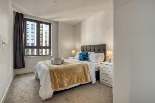 a white bedroom with a bed and a window at Hyde Park Luxury 2BR 2BA Balcony in London