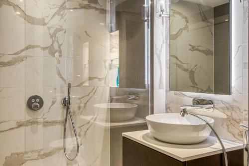 a bathroom with a sink and a glass shower at Hyde Park Luxury 2BR 2BA Balcony in London
