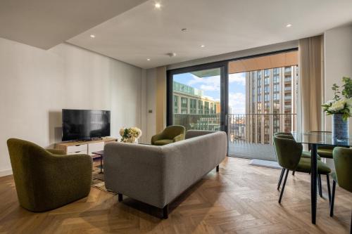 a living room with a couch and a table and a television at Hyde Park Luxury 2BR 2BA Balcony in London