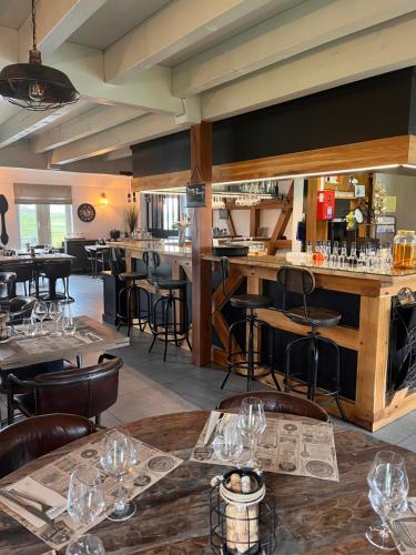 un restaurant avec des tables et des chaises et un bar dans l'établissement L'auberge du canal, à Brebotte