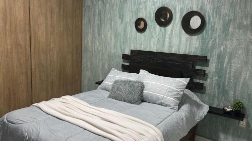 a bedroom with a bed and two clocks on the wall at Apartamento con Rooftop cerca de la Playa in Manzanillo