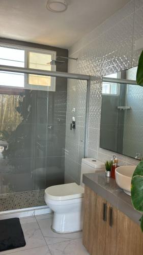 a bathroom with a toilet and a sink and a mirror at Apartamento con Rooftop cerca de la Playa in Manzanillo