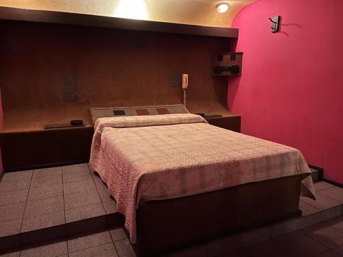 ルハン・デ・クージョにあるMotel Cocoviのピンクの壁のベッドルーム1室