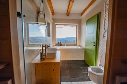 a bathroom with a green door and a sink and a tub at Holiday home in Trebnje - Kranjska (Krain) 53751 in Trebnje