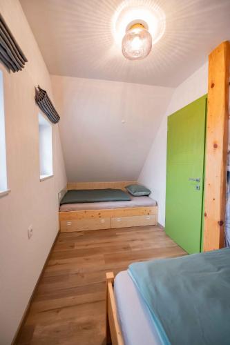a small room with a bed and a green door at Holiday home in Trebnje - Kranjska (Krain) 53751 in Trebnje