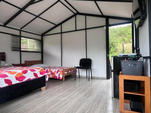 a bedroom with a bed and a desk in a room at Cabaña del Rio in Choachí