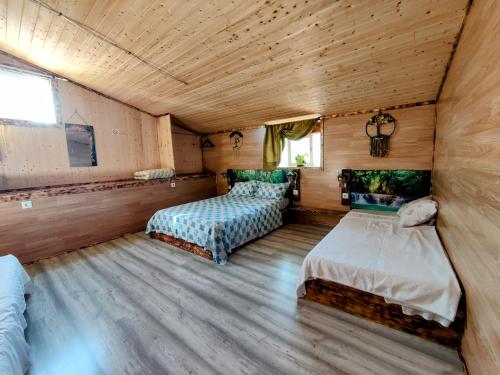 a bedroom with two beds in a room with wooden floors at Família 12-Casa Amazonia PT in Cernache