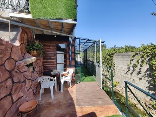 a balcony with a table and chairs and a stone wall at Família 12-Casa Amazonia PT in Cernache