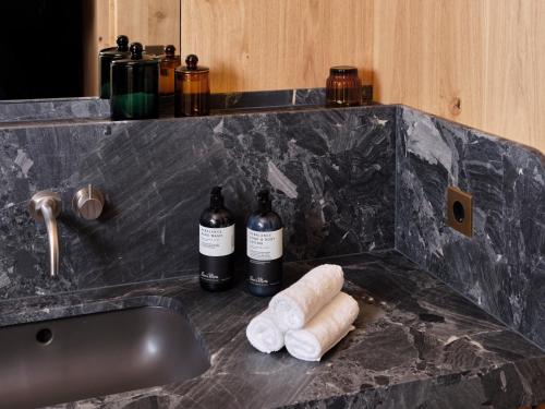 two bottles of wine on a counter next to a sink at Chiemgauhof Lakeside Retreat in Übersee