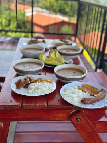 a wooden table with plates of food on it at Tahiti Casa Campestre in Santa Bárbara