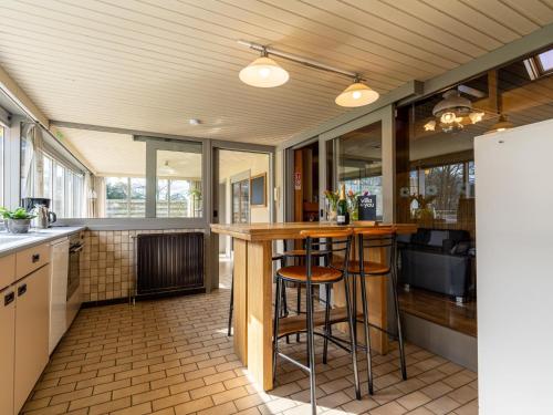 a kitchen with a bar with stools in it at De Kievelder in Grote-Brogel