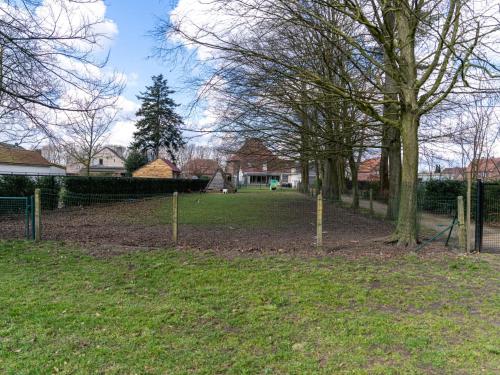 a park with trees and a fence in the grass at De Kievelder in Grote-Brogel