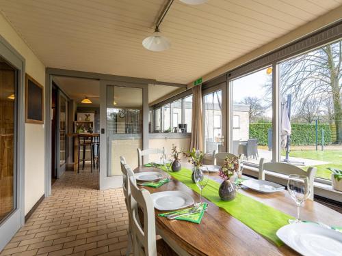 a dining room with a wooden table with white chairs and a tableablish at De Kievelder in Grote-Brogel