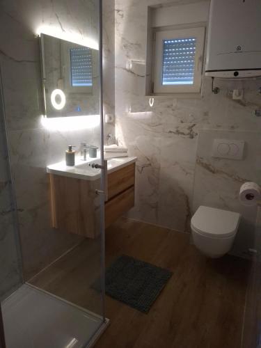 a bathroom with a shower and a toilet and a sink at Apartment Pag 6412c in Pag