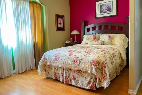 a bedroom with a bed with a pink wall at Sadie's Bed and Breakfast / Hotel in Tijuana