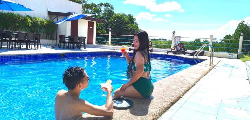 MVR Mariegold Resort في Suba: ولد وبنت يلعبون في المسبح