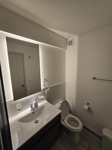 a bathroom with a sink and a toilet and a mirror at AMPLIO DEPARTAMENTO EN JESÚS MARÍa in Lima