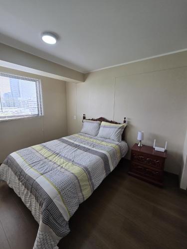 a bedroom with a large bed and a window at AMPLIO DEPARTAMENTO EN JESÚS MARÍa in Lima