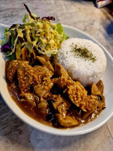 a plate of food with rice and a salad at Villa Alessandra Homestay in Moalboal