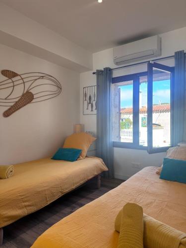 deux lits dans une chambre avec une fenêtre dans l'établissement Pied dans l'O 2 chambres, à La Seyne-sur-Mer