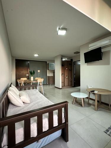 a bedroom with a bed and a living room at Departamento Condominio del Alto 3 H&L in Rosario