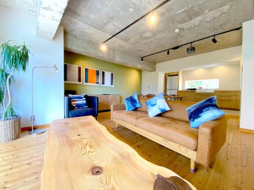 a living room with a couch and a table at プライベート天然温泉 - 広々清潔 - 素敵な非日常! Private Hot Spring - Spotless Modern Japanese in Ito
