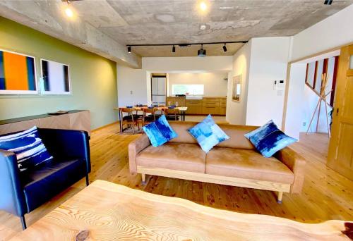 a living room with a couch and a table at プライベート天然温泉 - 広々清潔 - 素敵な非日常! Private Hot Spring - Spotless Modern Japanese in Ito