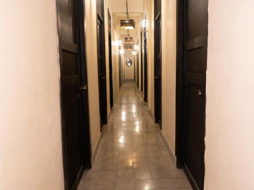 an empty hallway with a long aisle with black doors at La Vieja Habana Zona Colonial in Santo Domingo