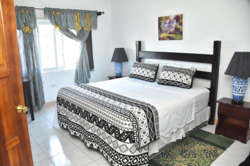 une chambre avec un lit noir et blanc et une fenêtre dans l'établissement Royal Exquisite Deluxe, à Kingston