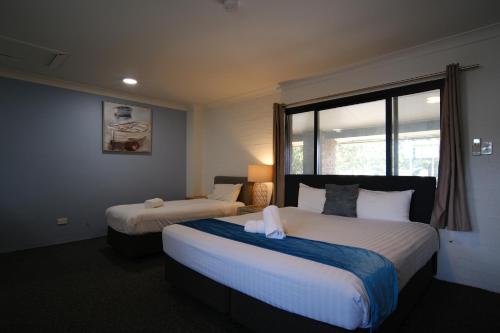 Postel nebo postele na pokoji v ubytování Lakeside Inn Wollongong
