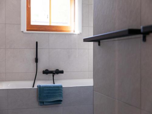 a bathroom with a bath tub and a blue towel at Woodland Cabin in Vencimont in Vencimont