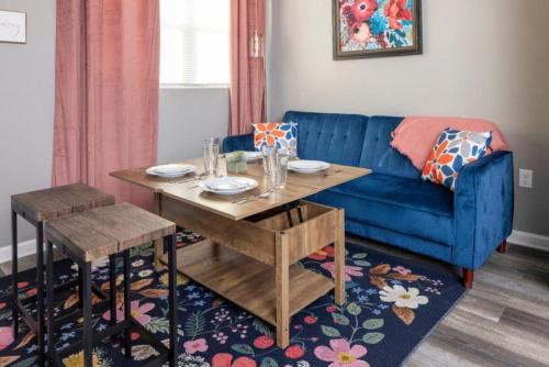 a living room with a blue couch and a table at Little Rock - Cozy Downtown Retreat in Little Rock