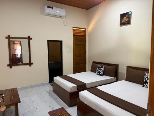 a bedroom with two beds and a mirror at Arana Holiday Resort in Kurundankulama