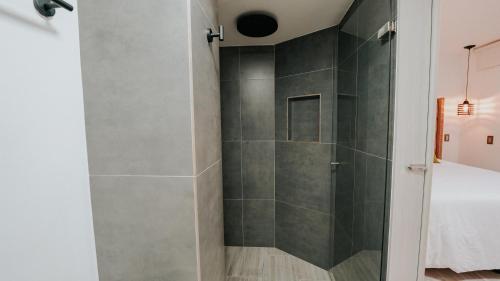 a bathroom with a shower with a glass door at Hotel Balcones del Estadio in Medellín