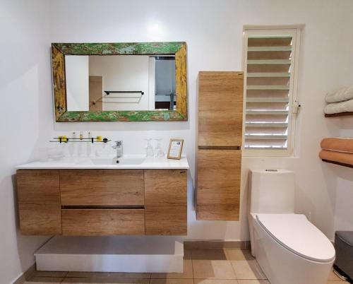a bathroom with a sink and a mirror and a toilet at Moorea Beach Lodge in Moorea