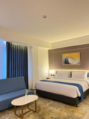 a hotel room with a bed and a couch at LYNN Hotel Tuban in Tuban