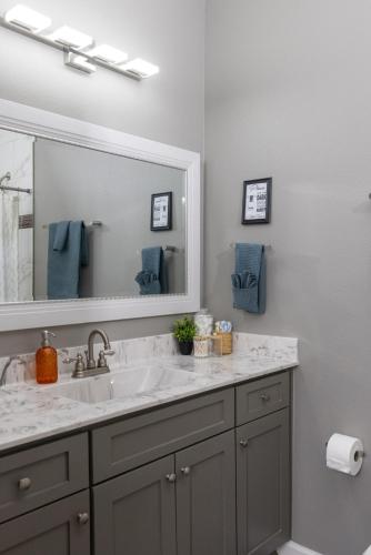 a bathroom with a sink and a large mirror at Little Rock Hideaway Cozy, Chic & Convenient in Little Rock
