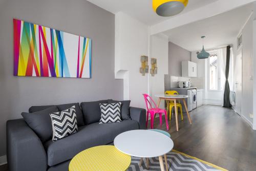 ein Wohnzimmer mit einem Sofa und einem Tisch in der Unterkunft Appartement Lyon Villeurbanne - Enjoy in Lyon in Villeurbanne