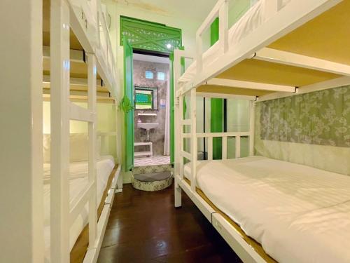 a room with two bunk beds and a bathroom at Green Teak House in Bangkok