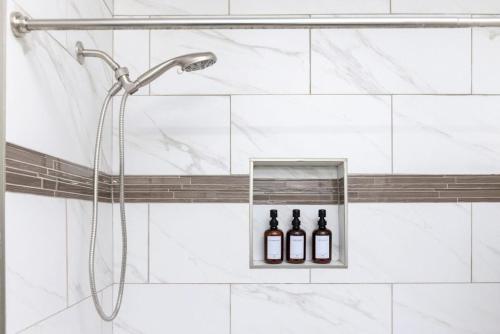 y baño con ducha y 3 botellas de vino. en Relax & Explore Downtown Little Rock, en Little Rock