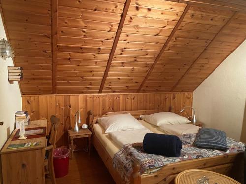 a bedroom with a large bed with a wooden ceiling at Schumacher's Landhaus - Bücherhotel in Friedeburg