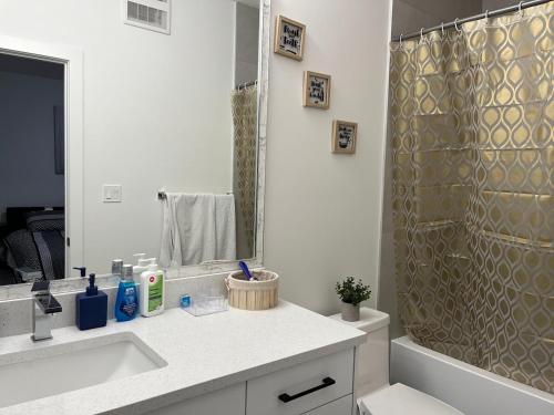 a bathroom with a shower and a sink and a mirror at Elegant 3BD Home in Beaumont, Double Garage in Nisku