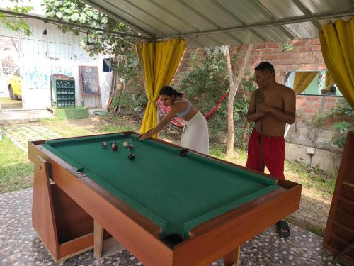 a man and a woman standing next to a pool table at Hostal Sol de Chosica in Chosica