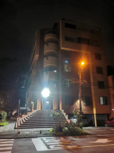 - un bâtiment avec des escaliers devant lui la nuit dans l'établissement Imbanaco Centro Medico Apartamento Estadio, à Cali