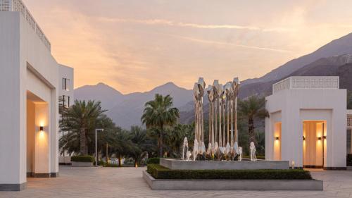 a fountain in front of a building with mountains in the background at InterContinental Fujairah Resort by IHG in Al Aqah