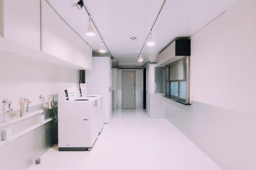 a hallway of an office with white walls and white appliances at Minimalist Loft Namba Compact Studio with a 24-hour Gym MA502 in Osaka