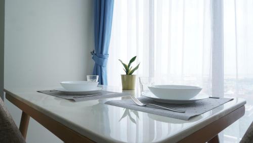 a table with two white bowls on top of it at Blue Belle Staycation Pollux Habibie in Batam Center