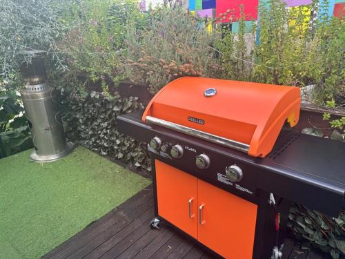 an orange grill sitting on a table on a deck at Riverside City Villa with Hot tub in Nelson